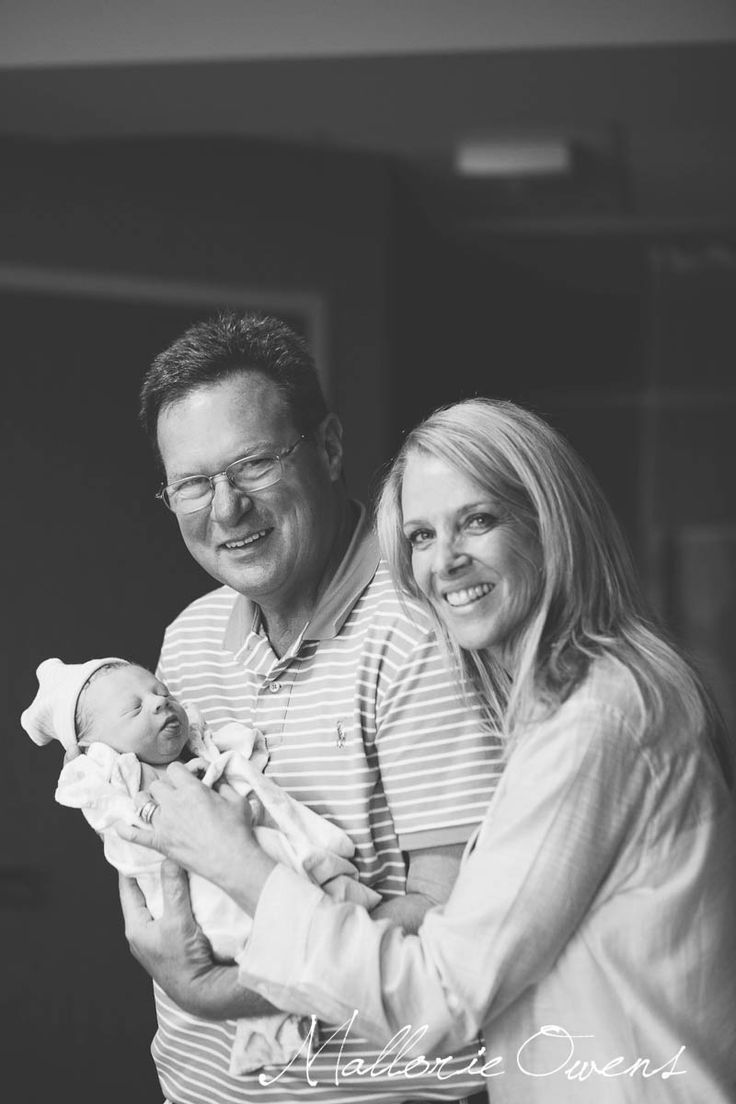 a man and woman holding a baby in their arms