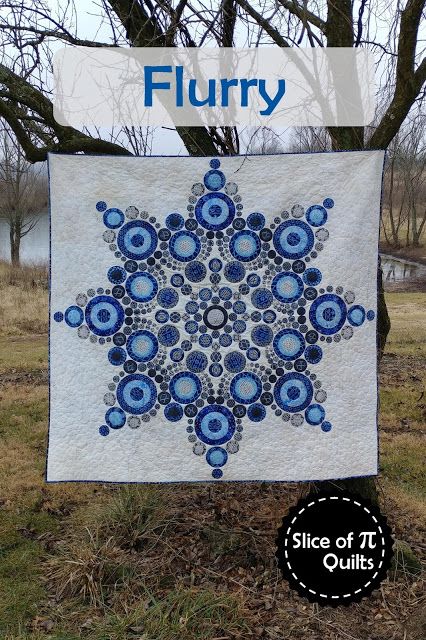 a blue and white quilt hanging from a tree with the words flurry on it