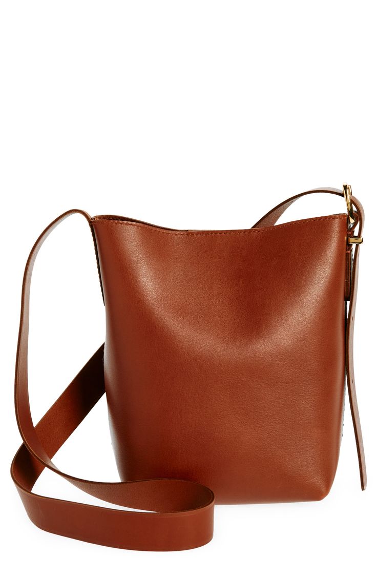 a brown leather handbag is shown on a white background and has a strap around the shoulder