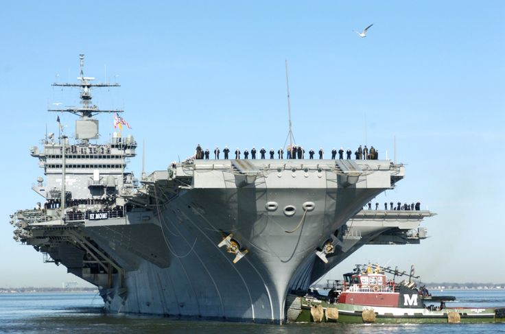 an aircraft carrier is docked in the water