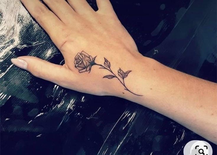 a woman's hand with a rose tattoo on it