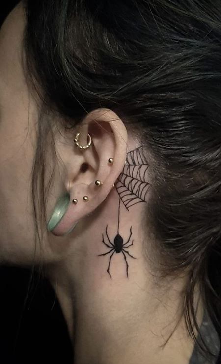 a woman with a spider tattoo on her ear