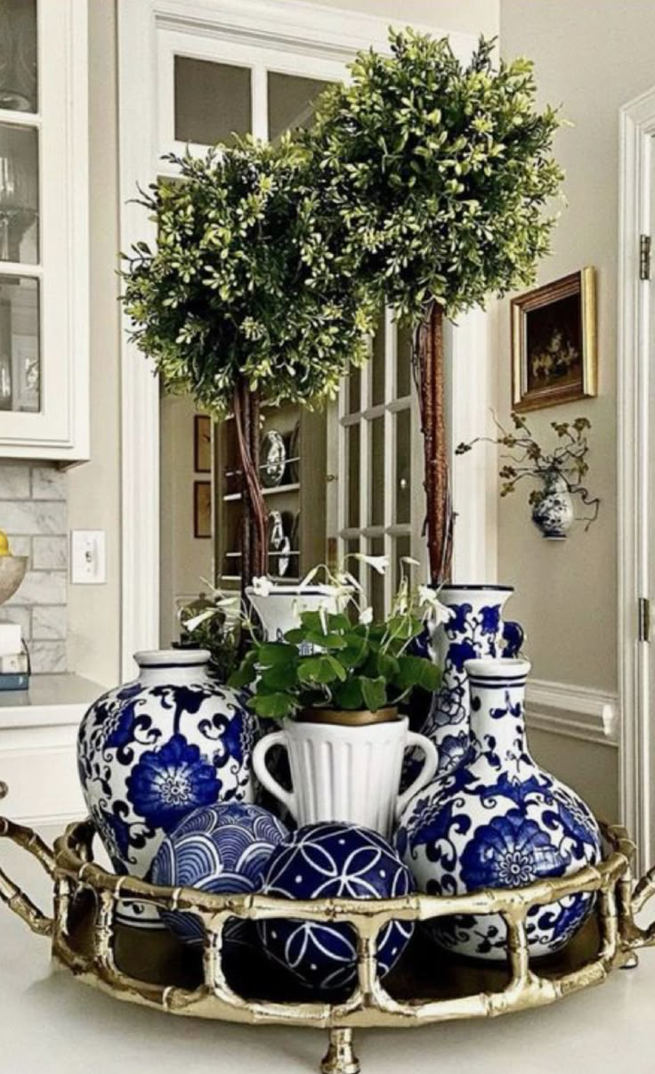 blue and white vases are arranged on a tray in the middle of a room