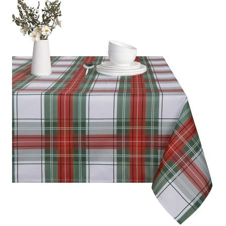 a table topped with a white vase filled with flowers next to a red and green plaid table cloth