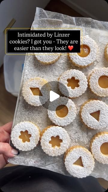 a person holding a tray full of donuts with frosting on them and the caption reads, intimate by linzer cookies? i got you they are easier than they look?