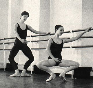 two women in black leotards practicing ballet moves