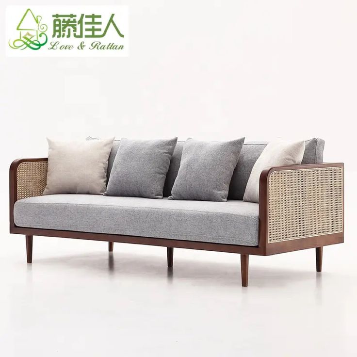 a couch with four pillows on it in front of a white wall and chinese writing