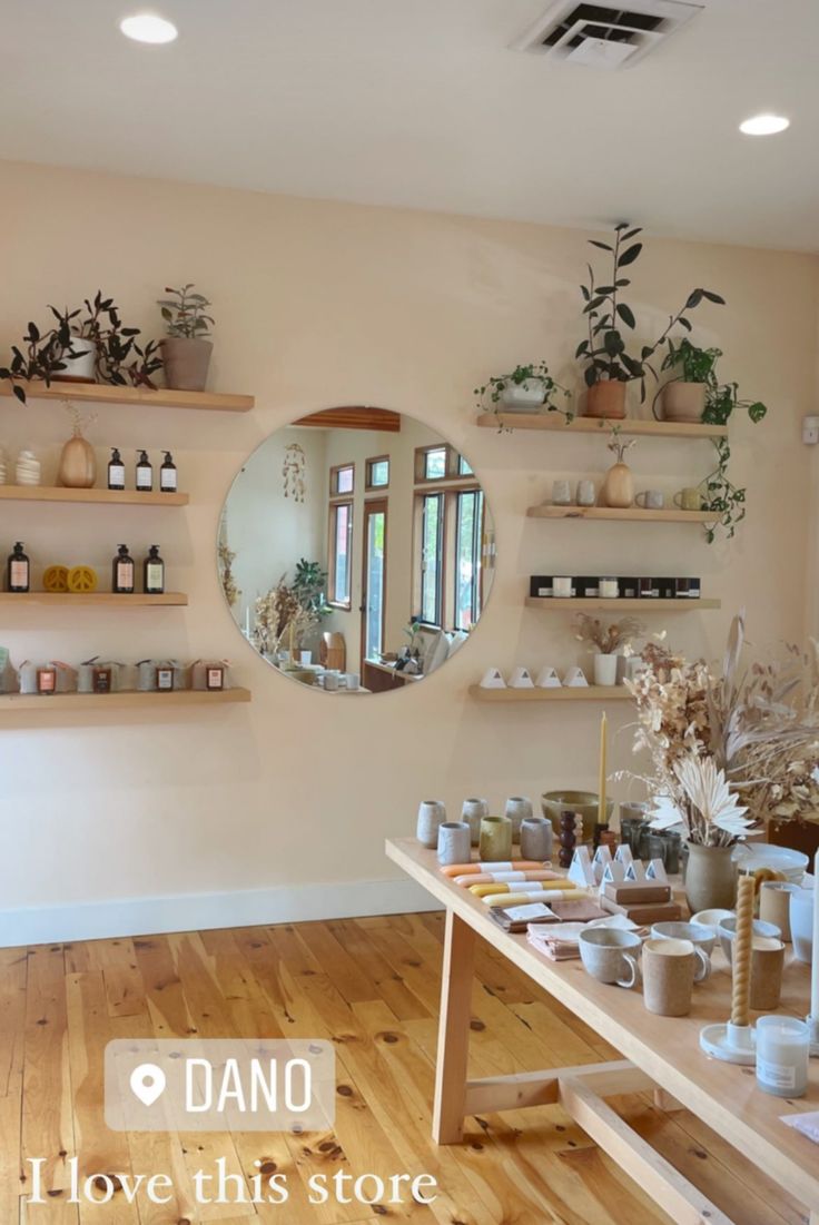 a room filled with lots of vases and shelves on the wall next to a mirror