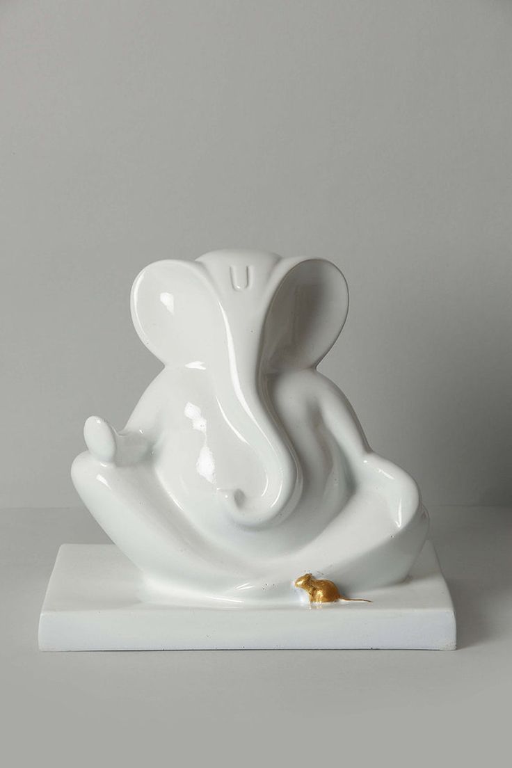 an elephant figurine sitting on top of a white base