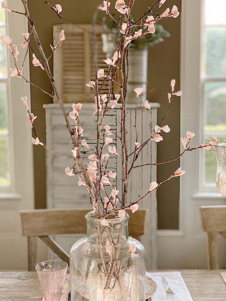 a vase filled with pink flowers on top of a wooden table