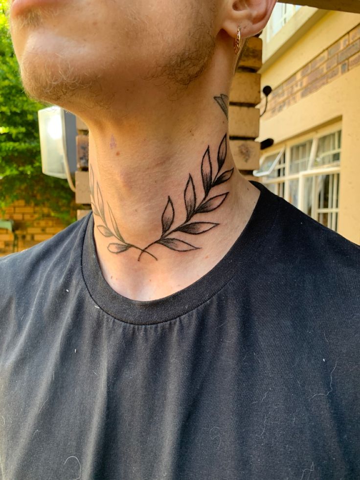 a man with a leaf tattoo on his neck