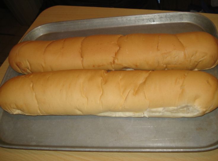 two long loafs of bread sitting on top of a metal pan