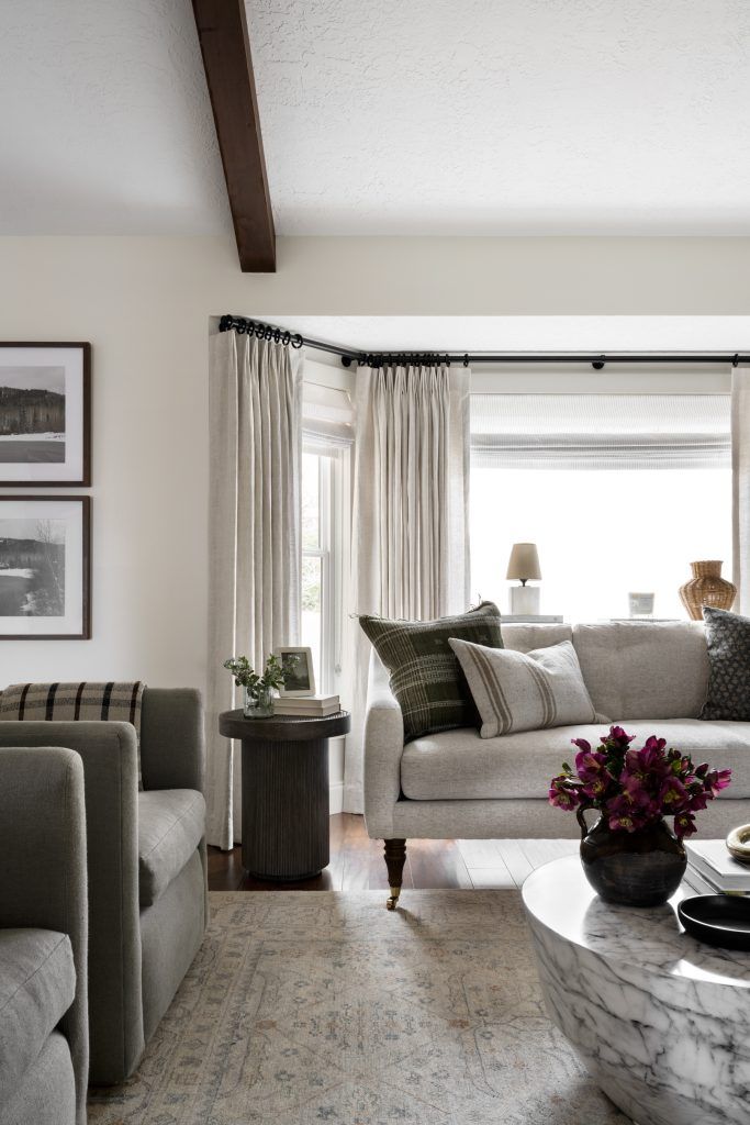 a living room with couches, tables and pictures hanging on the wall above them