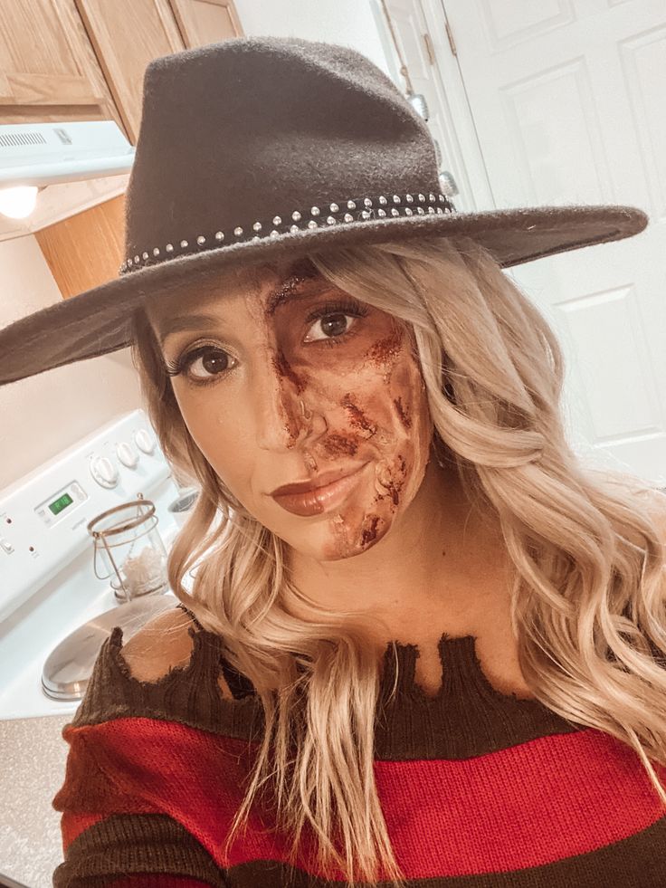 a woman in a hat with food all over her face and half eaten pizza on her face