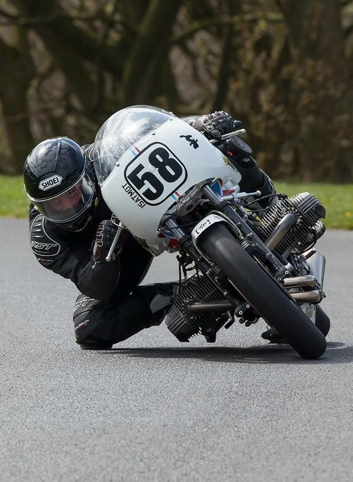 a man riding on the back of a motorcycle down a curvy race track