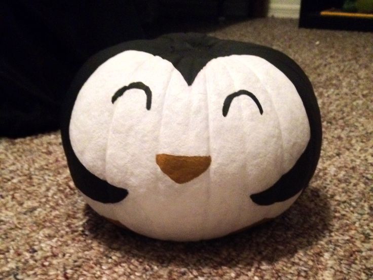 a black and white penguin pumpkin sitting on the ground