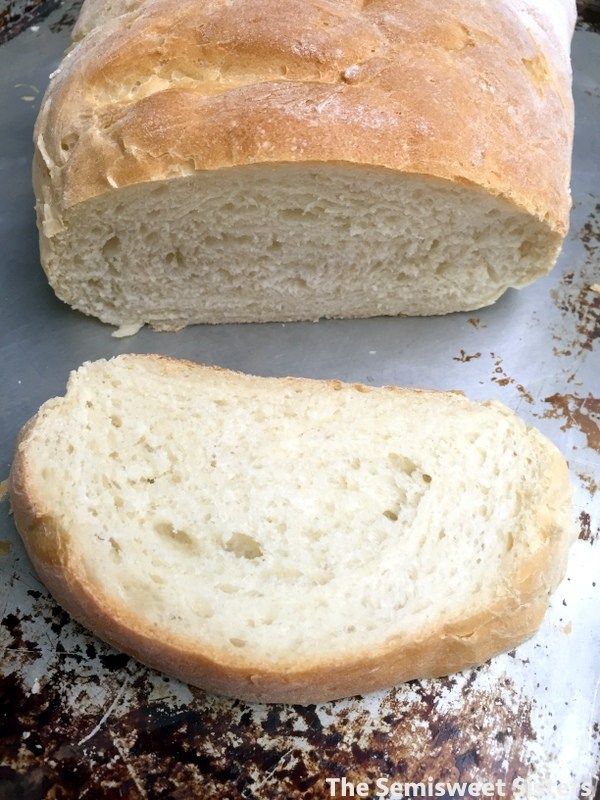 a loaf of white bread sitting on top of a metal pan next to a piece of bread