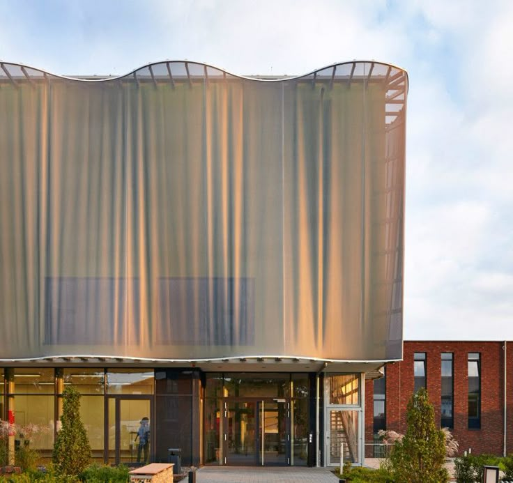 a large building with an awning over it's entrance and landscaping around it