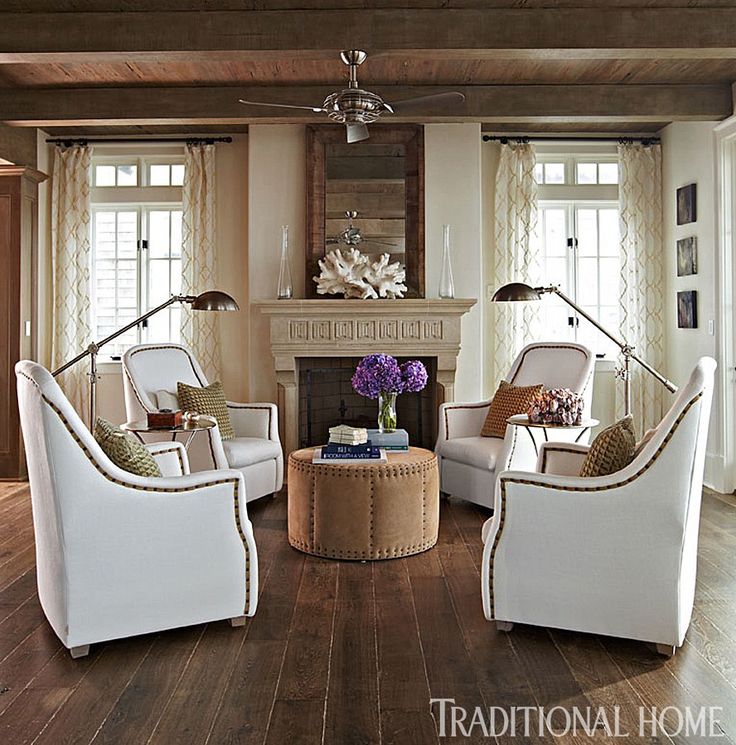 a living room filled with furniture and a fire place in the middle of a room