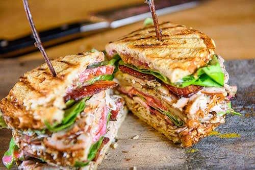 a cut in half sandwich sitting on top of a cutting board