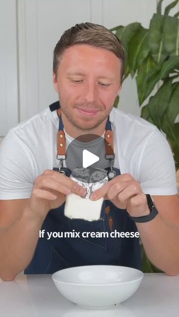 a man in an apron is making a bowl with cream cheese and he has his eyes closed to the camera