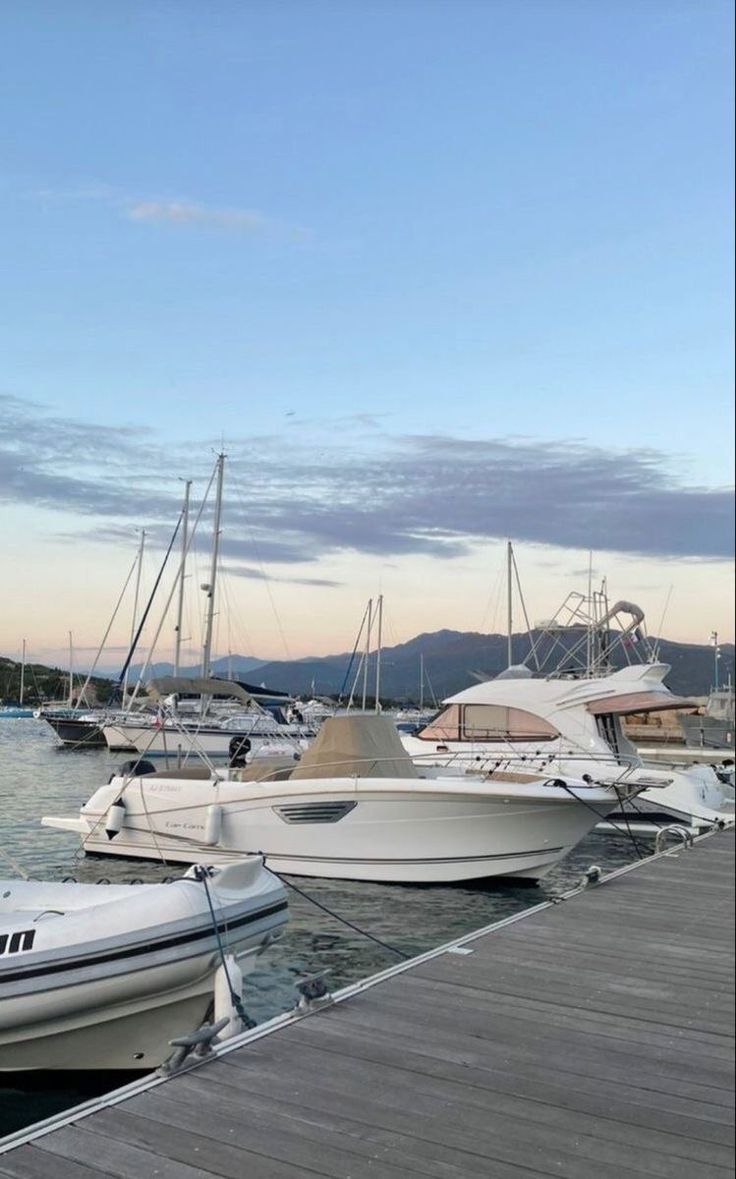 several boats are docked in the water at a dock