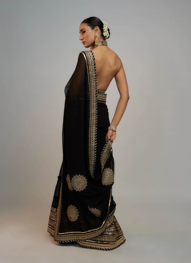 Editor's Note A classic drape sari with delicate gold embroidery lifts the patterns and add grace, paired with a beautiful bralette blouse speaks of opulence and grandeur, gold, jewel colours that are reminiscent of royalty! Wedding Black Pre-draped Saree With Intricate Embroidery, Elegant Pre-draped Saree For Navratri, Gold Pre-draped Saree For Diwali Evening, Evening Anarkali Pre-draped Saree With Cutdana, Anarkali Pre-draped Saree For Evening With Cutdana, Elegant Pre-draped Saree With Dupatta For Festivals, Elegant Festive Pre-draped Saree With Intricate Embroidery, Anarkali Evening Blouse With Traditional Drape, Anarkali Blouse Piece For Evening With Traditional Drape