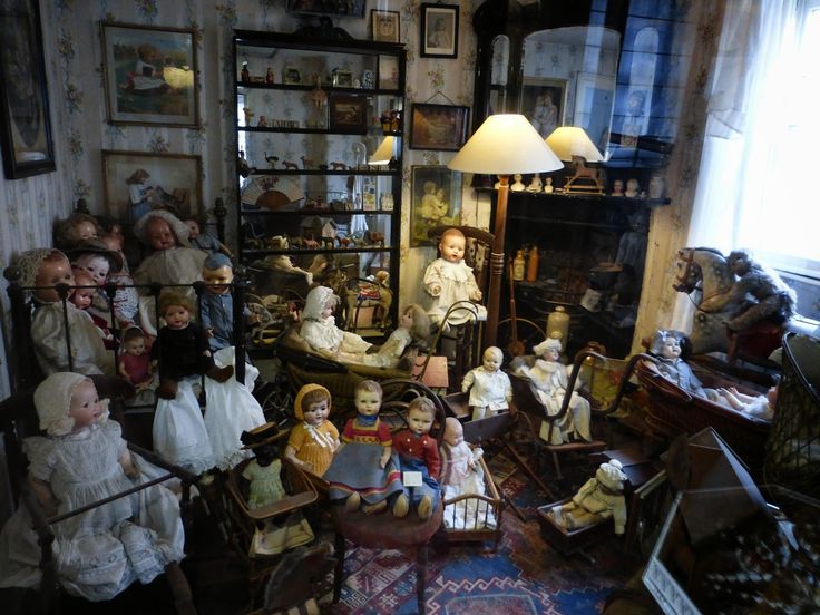 a room filled with lots of dolls and furniture