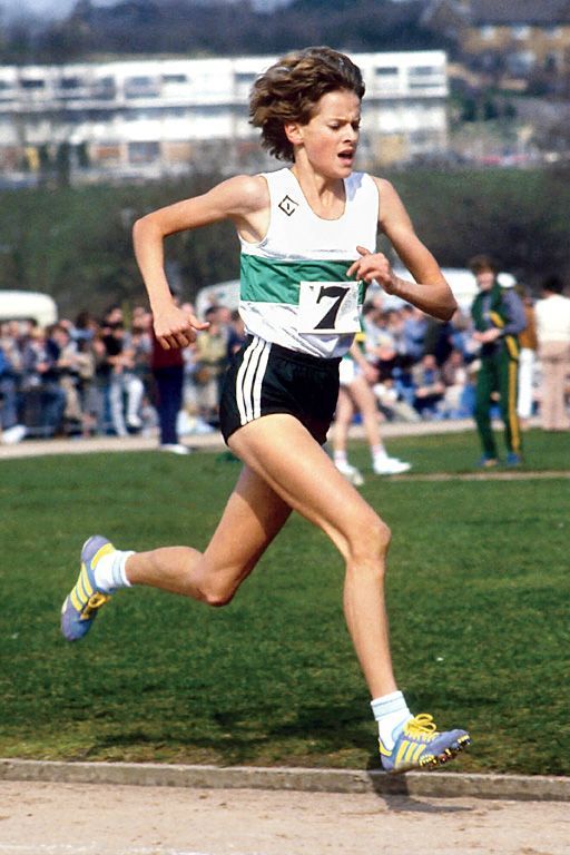 a woman running in a race with people watching