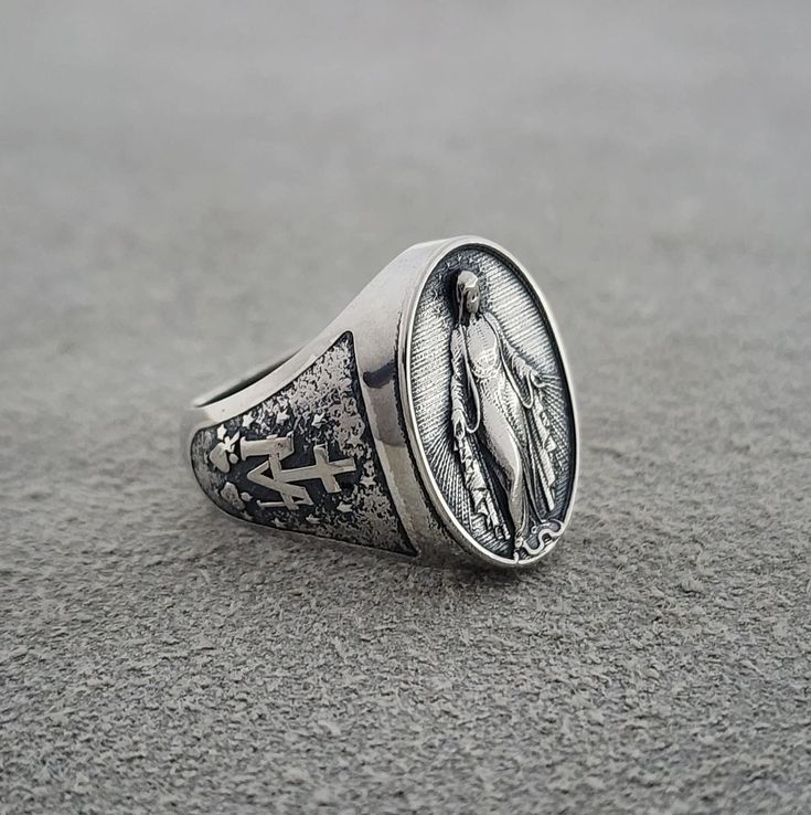 💍✨ Marian Consecration Ring ✨💍 Embrace the sacred and the divine with this beautifully crafted Virgin Mary Ring. Made from high-quality 925k sterling silver, this ring features the Pray of Miraculous Miracle Virgin Mary, making it a perfect Christmas Gift or a special piece of religious jewelry. 🔨 Handcrafted Excellence: Each ring is meticulously handcrafted by skilled artisans, ensuring a unique and high-quality piece. The intricate details and polished finish highlight the ring's exceptional craftsmanship and attention to detail. 🌟 Virgin Mary Design: The centerpiece of this ring is an exquisite depiction of the Virgin Mary, also known as Meryem, the mother of Jesus. This design embodies purity, grace, and the miraculous power of faith. 💎 Premium Quality: Made from high-quality 925k Symbolic White Gold Engraved Ring Handmade, Symbolic Handmade White Gold Engraved Ring, Symbolic Handmade Engraved White Gold Ring, Silver Jewelry With Miraculous Medal For Gift, Handmade Spiritual White Gold Signet Ring, Spiritual Hallmarked Signet Ring Gift, Spiritual White Gold Engraved Ring Gift, Spiritual White Gold Engraved Ring For Gift, Sterling Silver Spiritual Rings For Collectors