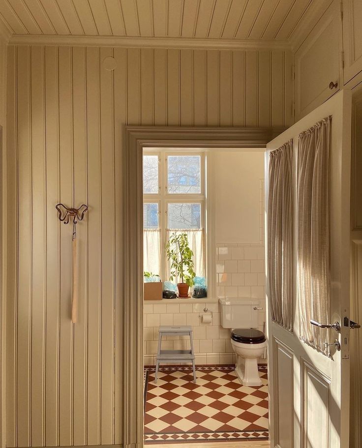 an open door leading to a bathroom with a checkered floor