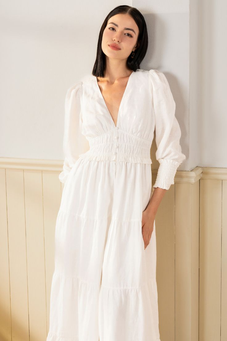 Georgia Maxi Dress will make a lasting impression at your next spring event! With an elastic waist, long sleeves, and tiered peasant skirt. LENGTH: 52" from top of shoulder FABRICATION: 100% White Linen STYLE#;DR-21450 White Linen - WHITE-S24﻿ *Dry Clean or wash on cold and hang flat to dry *Model is wearing size XS White Tiered Smocked Dress For Spring, White Tiered Dress With Smocked Bodice For Spring, Tiered Midi Dress With Smocked Cuffs For Brunch, White Midi Dress With Smocked Cuffs For Spring, Long Sleeve Peasant Dress For Brunch, White Long Sleeve Dress With Smocked Bodice, White Long Sleeve Smocked Dress For Spring, Spring Tiered Linen Midi Dress, Long Sleeve Ruffled Peasant Dress For Brunch