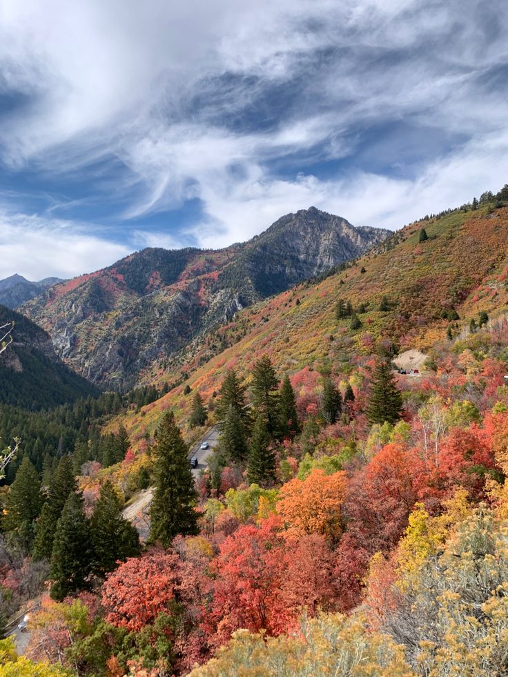 the mountains are covered in colorful foliage and trees with red, yellow, green, and orange leaves