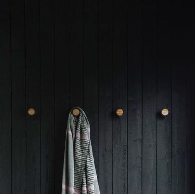 a towel hanging on the side of a black wall