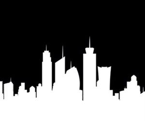 a black and white cityscape with tall buildings in the night sky, silhouetted against a dark background