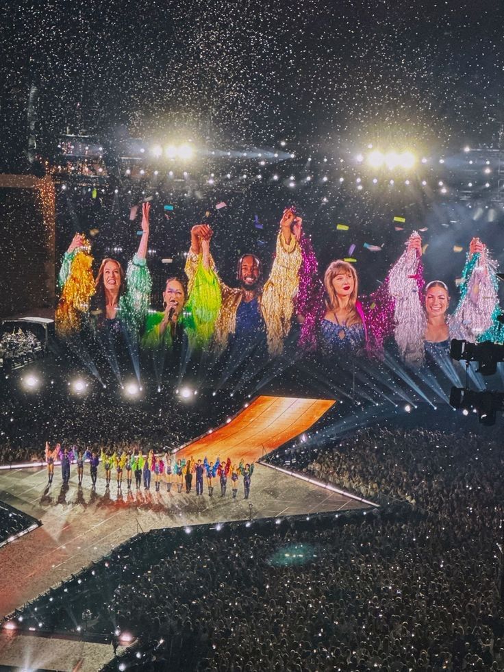 a large group of people standing on top of a stage in front of a crowd