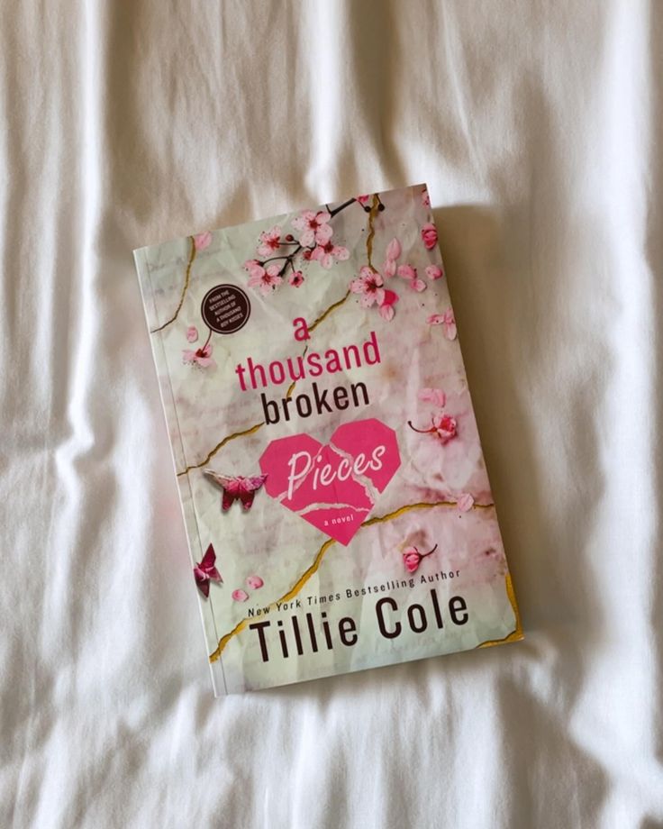 a thousand broken pieces by tillie cole on a white bed sheet with pink flowers