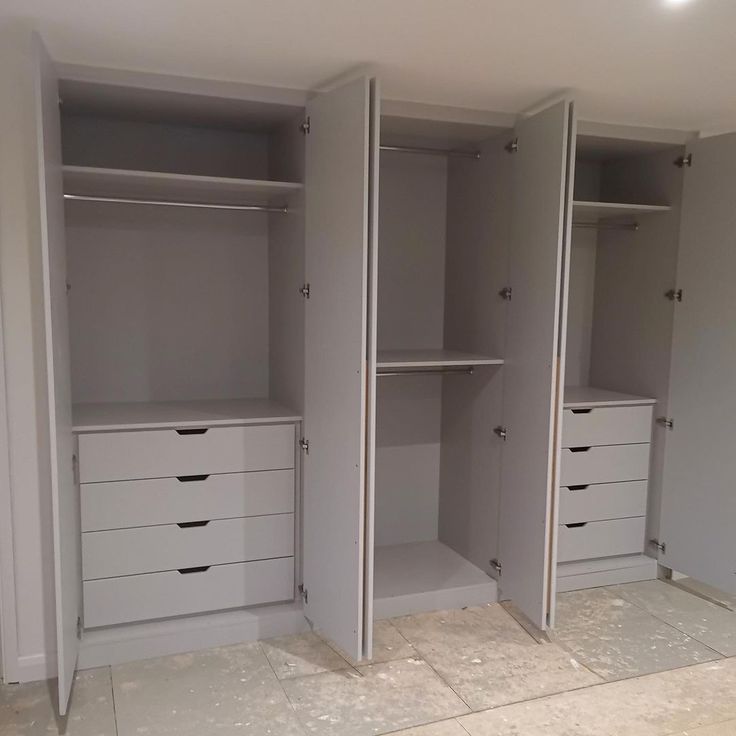 an empty walk in closet with white drawers