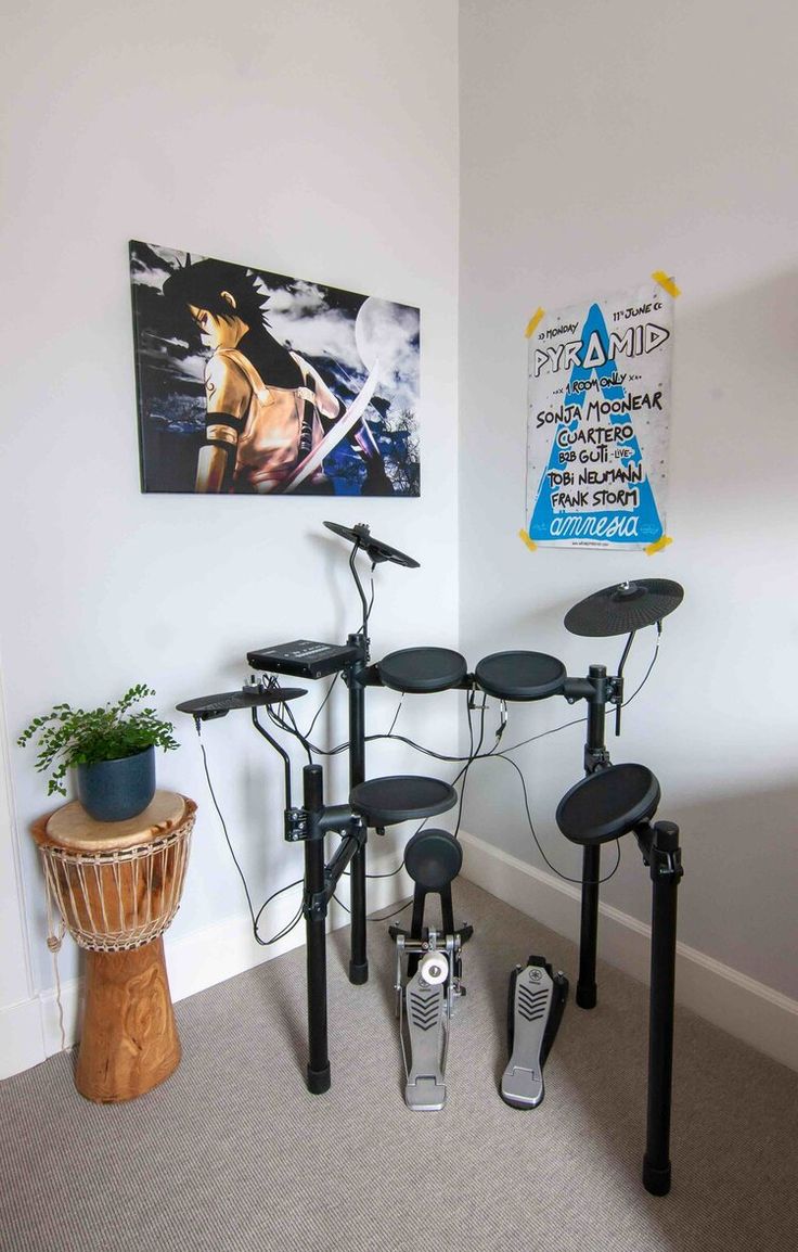 two electronic drums are sitting in the corner of a room with a plant on the floor