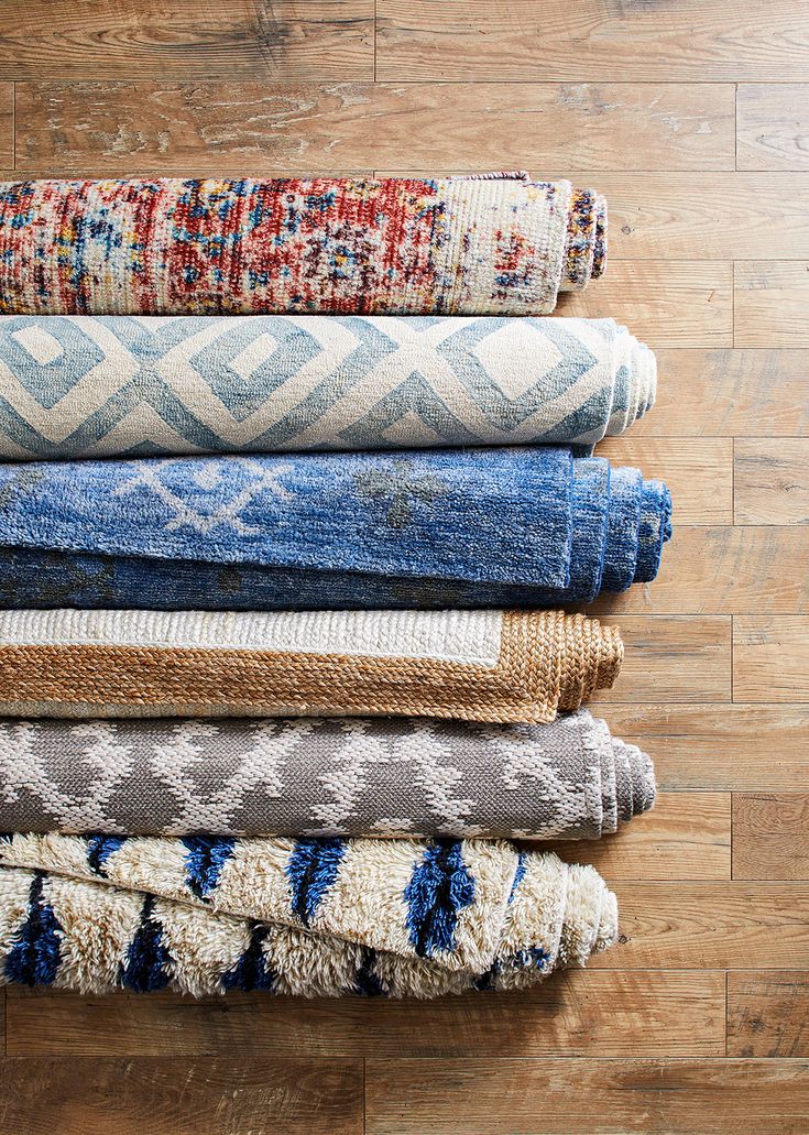 a pile of rugs sitting on top of a wooden floor