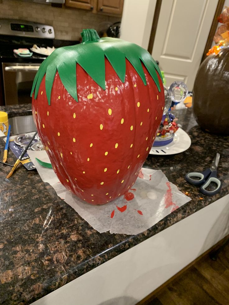 a large plastic strawberry sitting on top of a counter