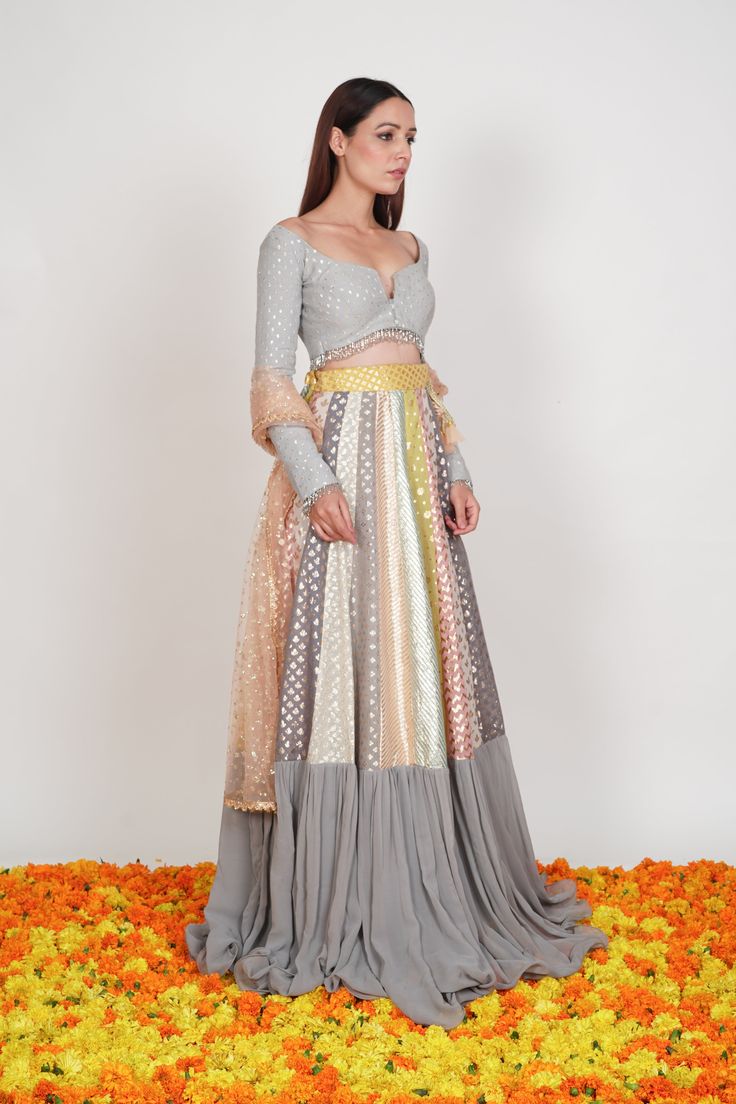 Editor's Note The Multi Pastel Colored Lehenga Set with multiple chanderi patterns is beautified by the gathers at the flare and the Dupatta.Fabric: Chanderi, GeorgetteColor: Pastel greyCare: Dry Clean Only Customize Your Outfit Can't find the size you're looking for? No stress. Just select the size "Custom" while adding the item to your cart. We will follow up with you for your body measurements. To request a color or design customizations, please contact our customer care by using our "Ask us Transitional Multicolor Sharara In Chanderi, Transitional Multicolor Chanderi Sharara, Multicolor Georgette Sharara For Navratri, Navratri Multicolor Georgette Sharara, Multicolor Georgette Sets For Navratri, Anarkali Style Multicolor Palazzo Set For Reception, Multicolor Anarkali Set For Reception And Transitional Season, Multicolor Blouse Piece With Sheer Dupatta For Reception, Multicolor Palazzo Set For Wedding And Transitional Season