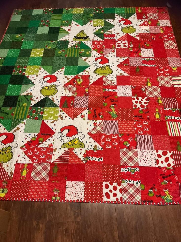 a red and green christmas quilt on a wooden floor