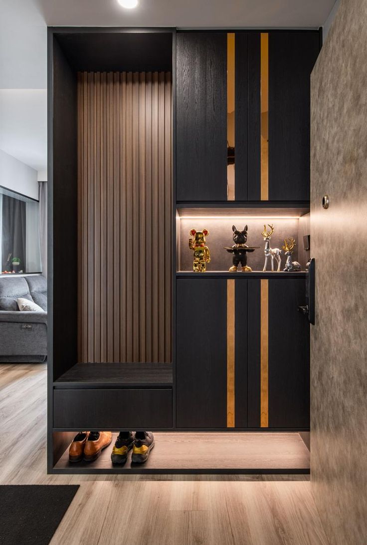 an entry way with wooden paneling and black cabinetry, lighted by recessed lights