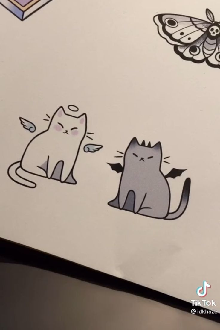 two cats sitting next to each other on top of a white sheet with butterfly stickers