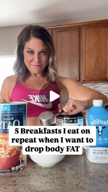 a woman standing in front of a kitchen counter holding a measuring cup with food on it