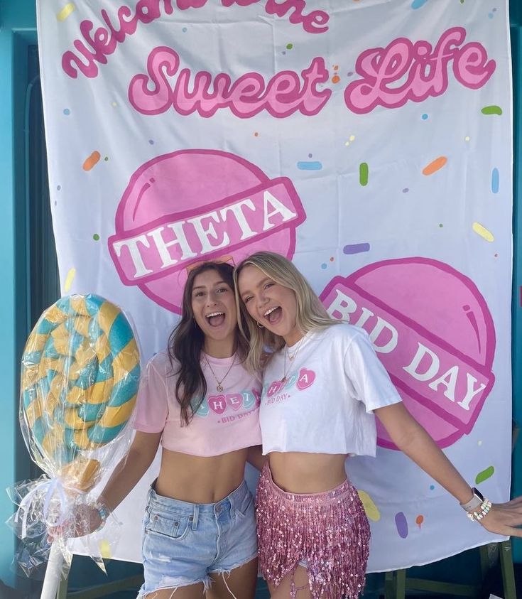 two women standing next to each other in front of a sign that says sweet life