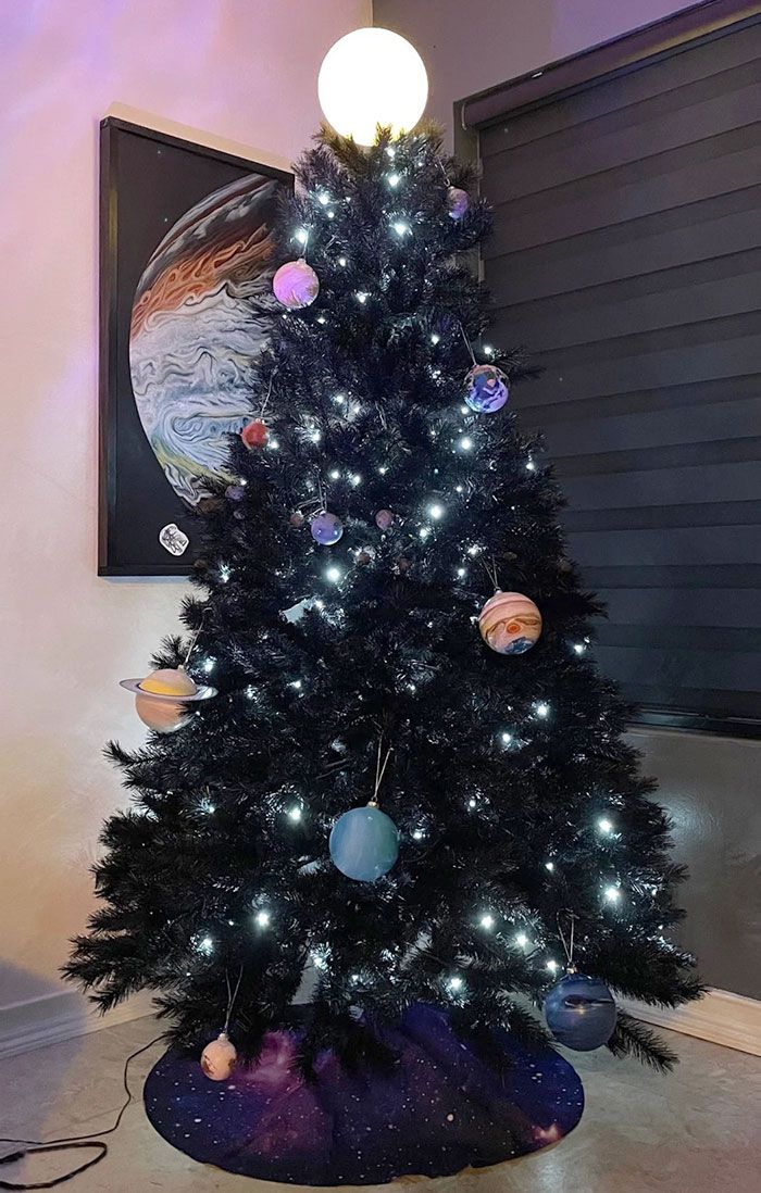 a black christmas tree with planets on it