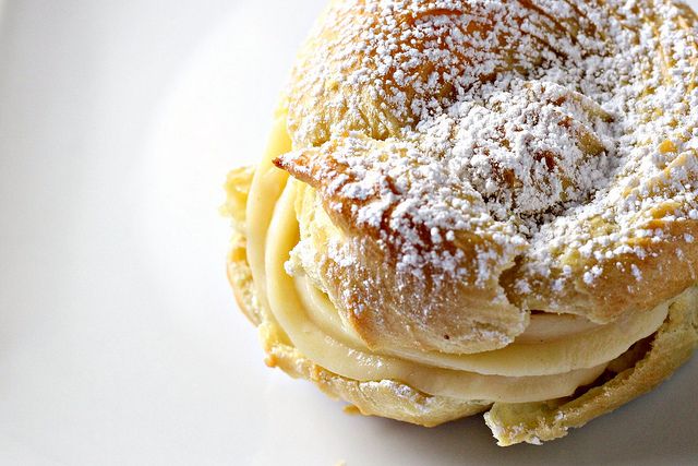 a pastry with powdered sugar sits on a white plate