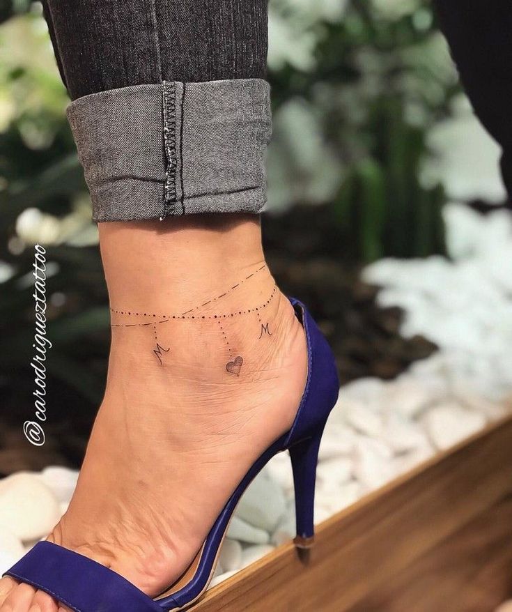 a woman's foot with a small tattoo on it